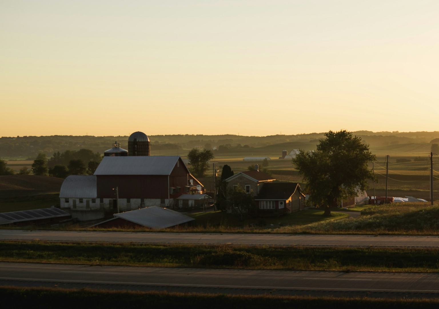 Farm buildings on rolling countryside at golden hour