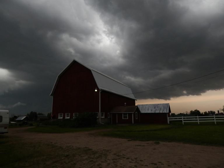 Dark storm clouds building over a red barn in rural Middle Tennessee