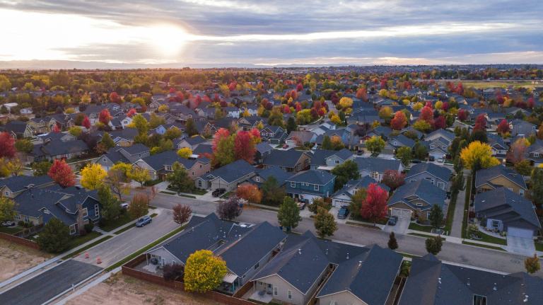 Aerial view of a suburban neighborhood with autumn trees at golden hour, the kind of subdivision living found around La Vergne, TN
