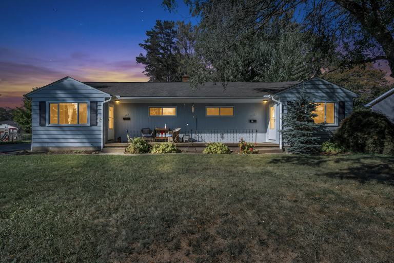 A single-story home at dusk with warm glowing windows, a front porch and mature trees, the kind of house Middle Tennessee buyers insure